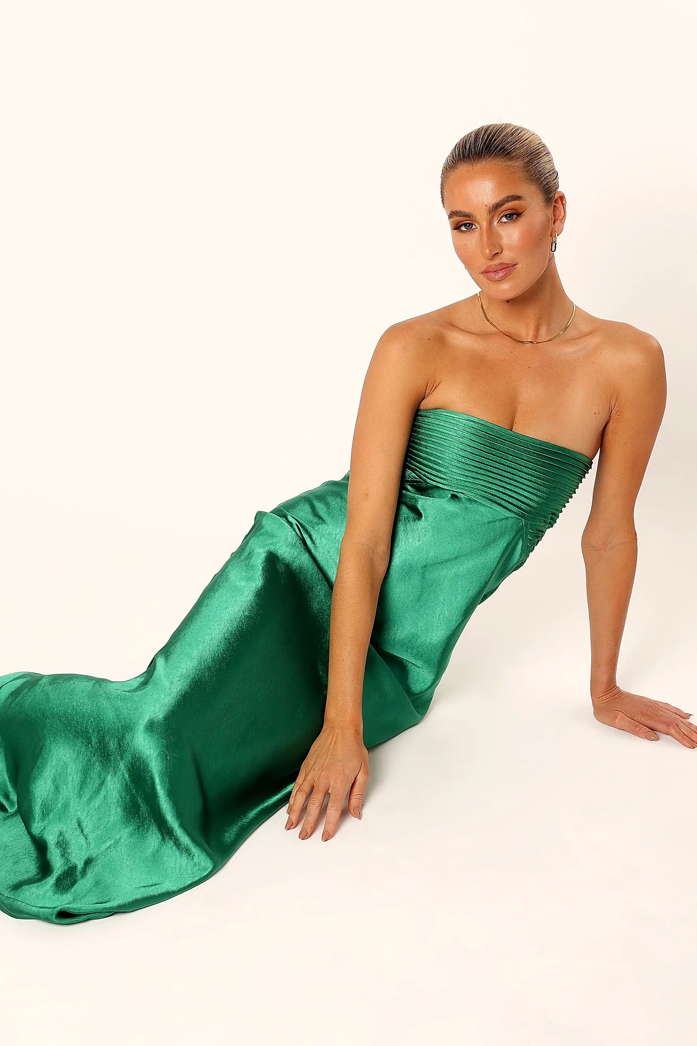 Pleated bodice detail on an emerald satin maxi dress