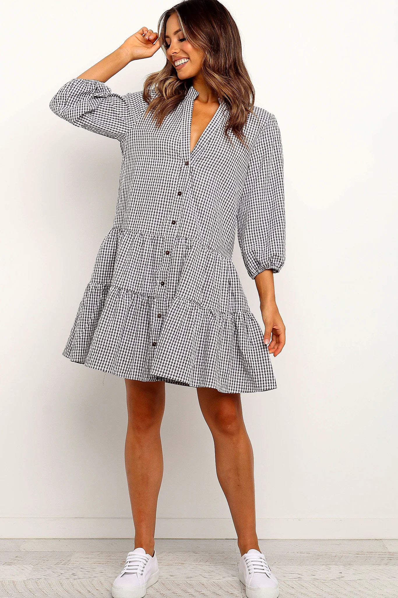 Full view of a tiered gingham oversized mini dress