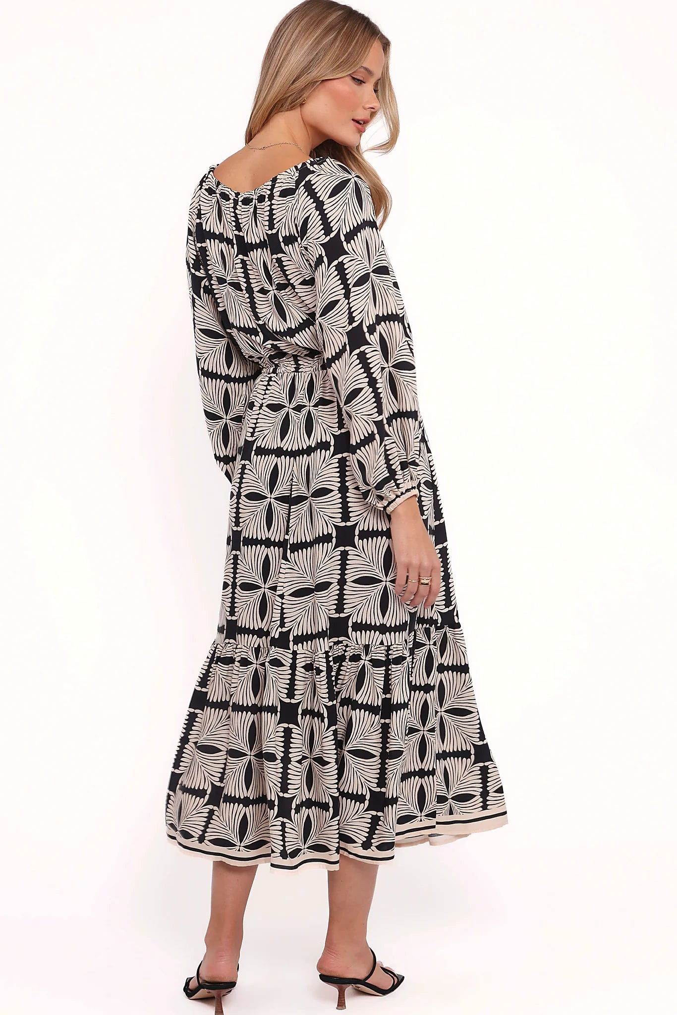 Full length view of a black geo print off shoulder midi dress