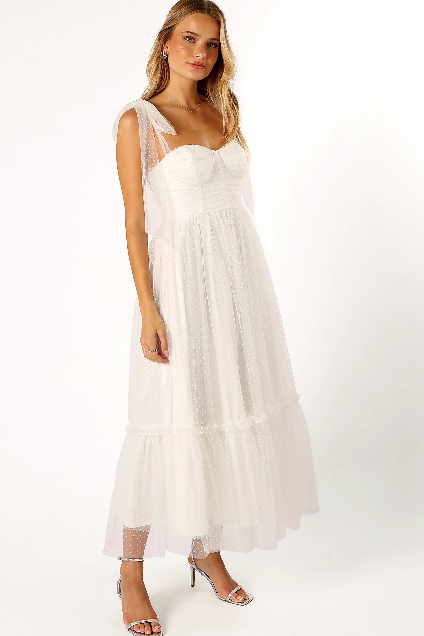 Full length view of a white polka dot tulle overlay midi dress