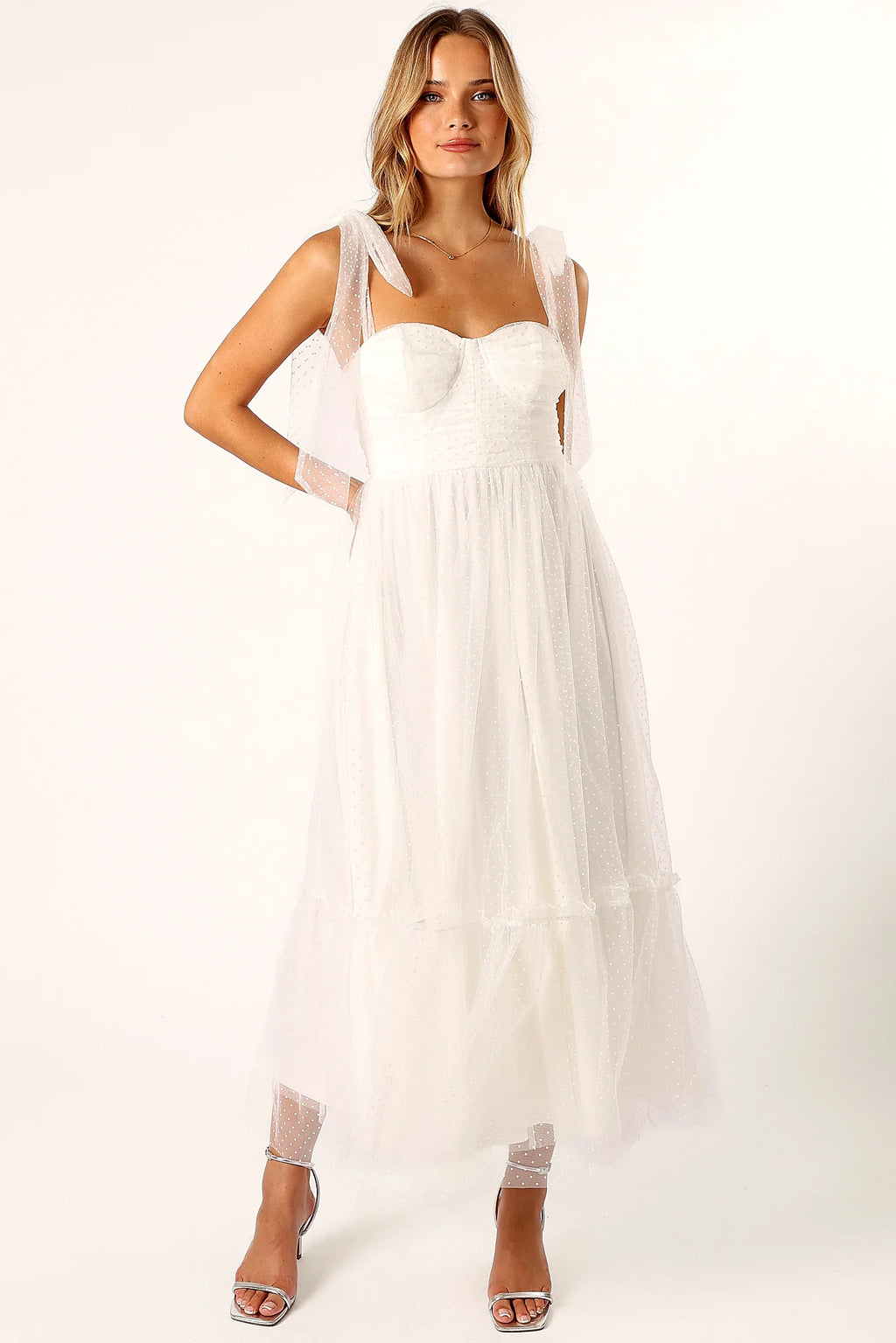 Ruffle detail on the hemline of an off white midi dress