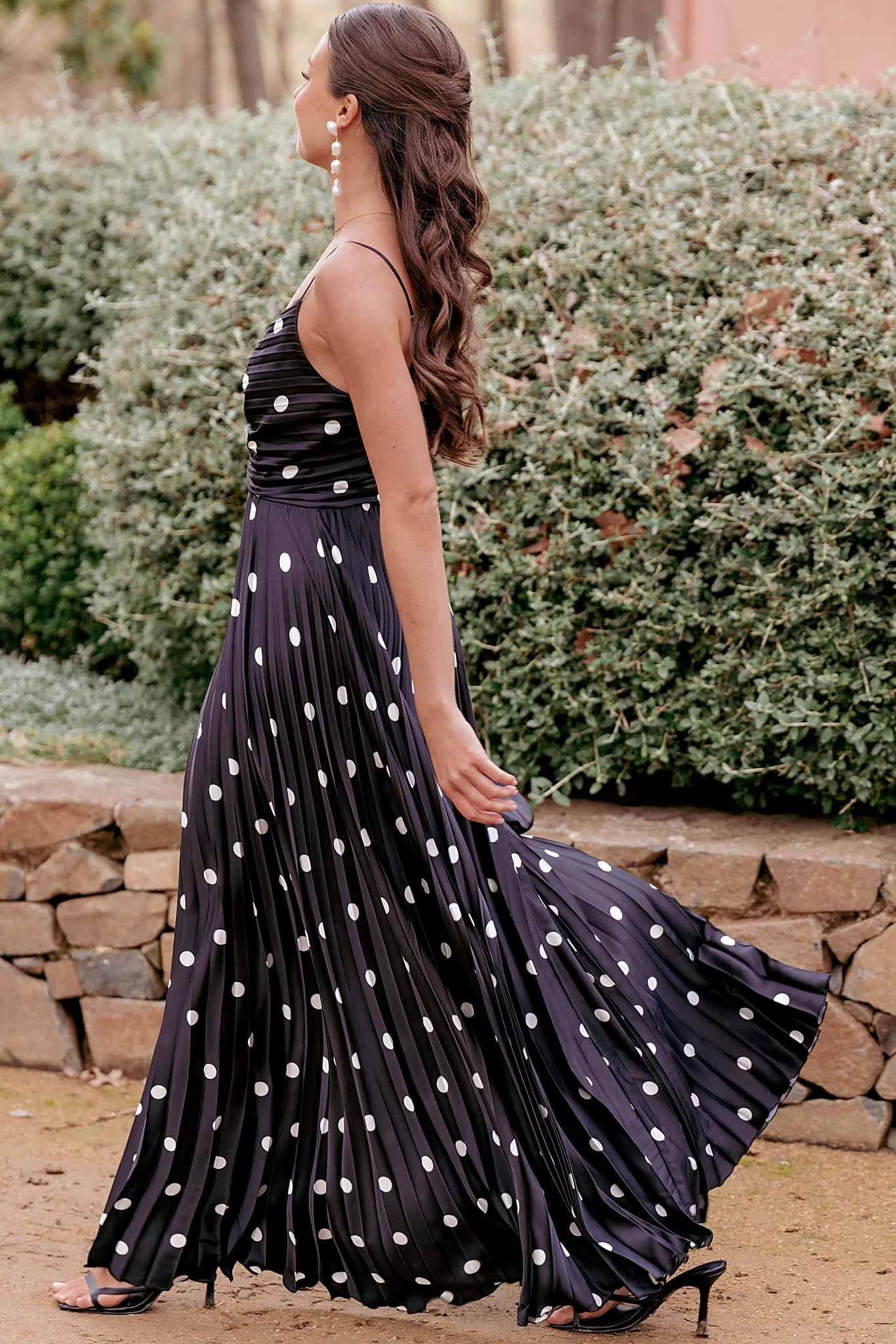 Delicate pleated fabric on a black satin maxi dress
