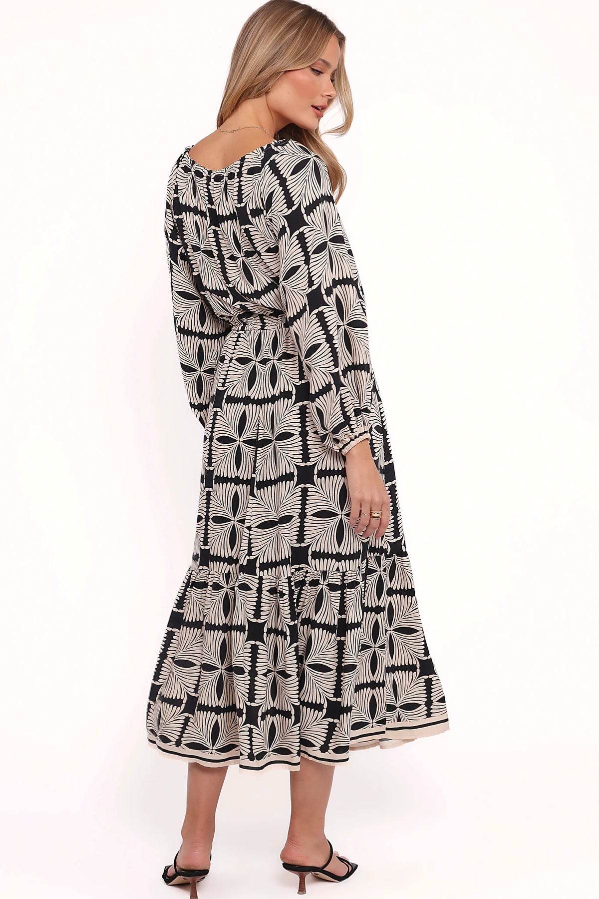 Full length view of a black geo print off shoulder midi dress