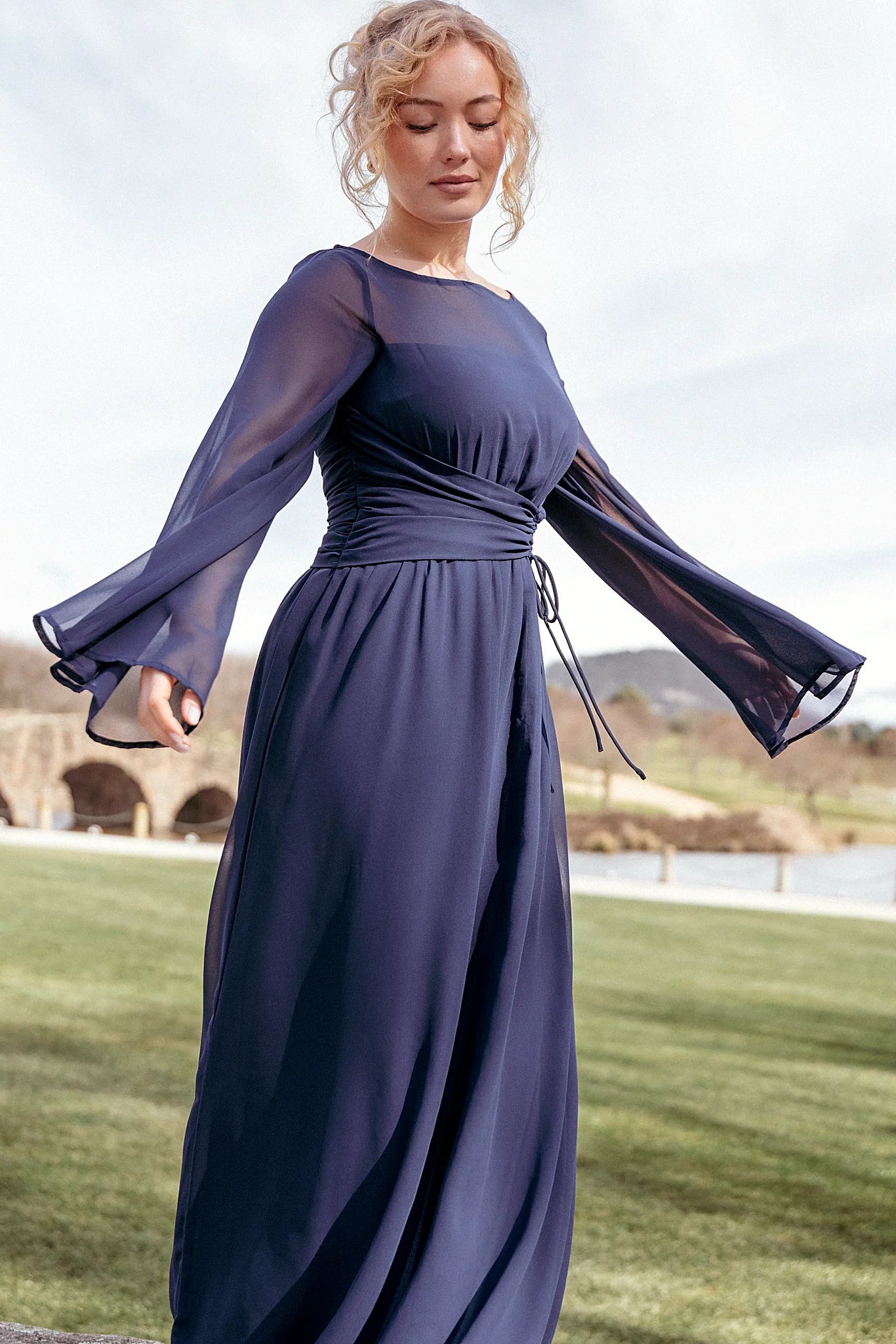 Navy maxi dress with a high round neckline and long flare sleeves