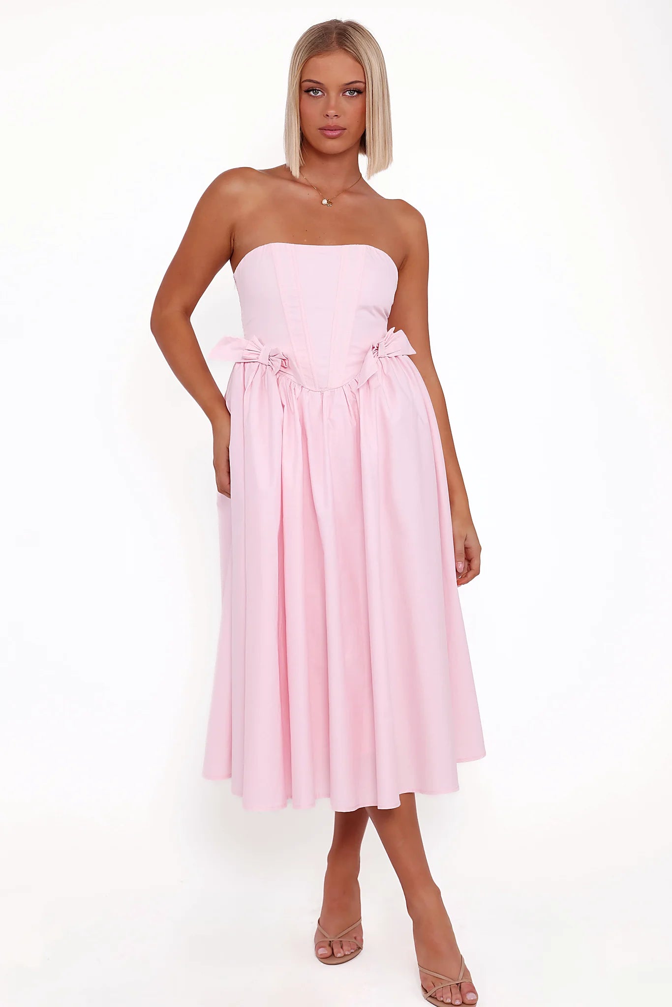 Pink strapless midi dress with a boned bodice and waist bow