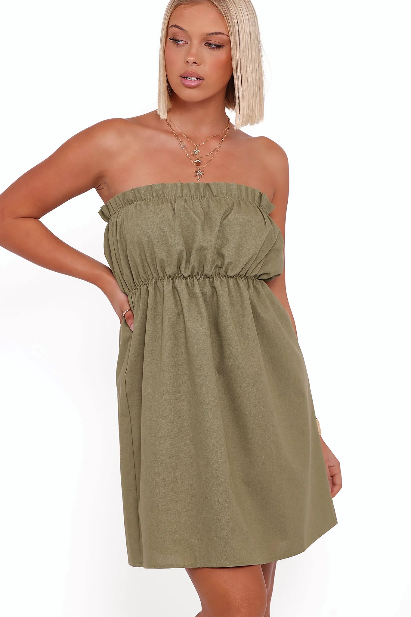 Ruffle trim along the neckline of a green strapless mini dress